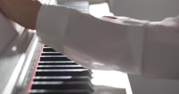 Kobieta lub dziewczyna Student lub zawodowy pianista gra muzykę klasyczną na pięknym białym fortepianie, ręce pianisty zbliżenie w zwolnionym tempie. Klucze fortepianowe zamykają się w ciemnych kolorach. 4k — Wideo stockowe