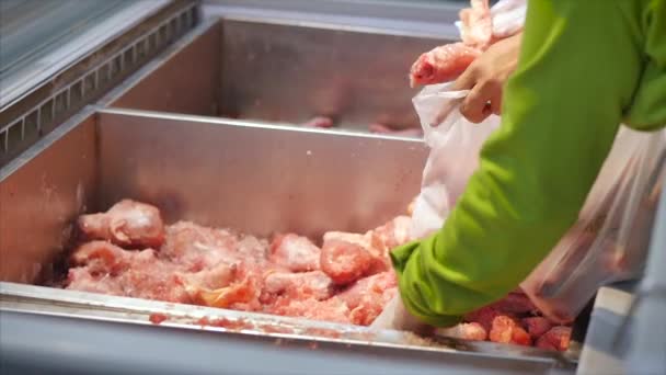 Жінка купує м'ясо, дивиться на шматки м'яса на курячі шматочки м'яса з щипцями на ринку, в супермаркеті . — стокове відео