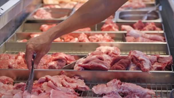 Dłonie kupującego w sklepie, męskie ręce zbliżenie wybrać lub kupić kawałki mięsa z szczypcami na rynku, w supermarkecie. — Wideo stockowe
