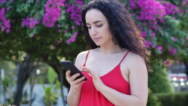 European Young Girl or Woman Cute Cheerful Girl Brunette typing texting on the smartphone, woman talking on phone. Young woman calling via mobile phone. Young woman checking mail by mobile phone. — Stock Video
