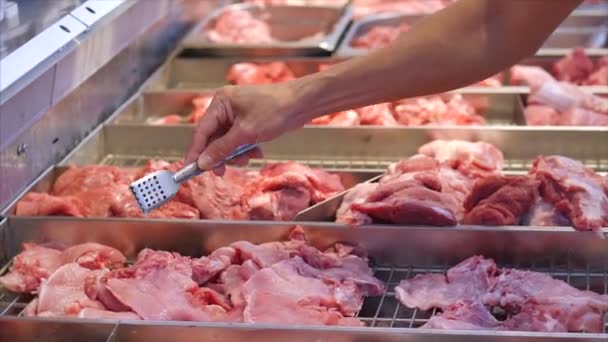 Las manos del comprador en la tienda, manos masculinas primer plano elegir o comprar trozos de carne con pinzas en el mercado, en el supermercado . — Vídeos de Stock
