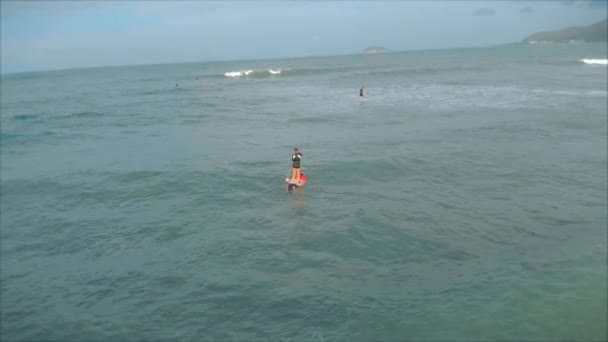 Flygfoto från ovan Atletiska unga kvinnor och män surfa, rida stora vågor med starkt dagsljus, surfare väntar på sin våg. — Stockvideo