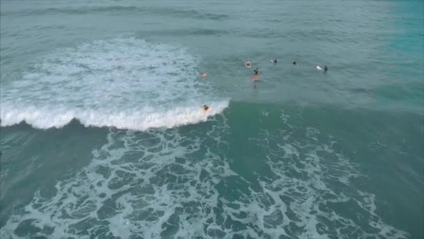 上からの空中ビューアスレチック若い女性と男性サーフィン,明るい日差しと大きな波に乗って,サーファーは彼の波を待っています. — ストック動画