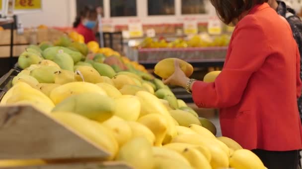 A mulher faz compras num supermercado, compra comida, escolhe frutas no mercado, no supermercado. Aquisição . — Vídeo de Stock