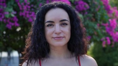 Sokak manzaralarının arka planında kameraya bakan Avrupalı esmer bir kızın portresi..