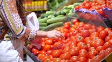 Güzel genç kadın ya da anne süpermarketten alışveriş yapıyor, süpermarketten yemek, sağlıklı yiyecekler, domates, avokado, meyve, portakal ve süpermarket ürünleri seçiyor..