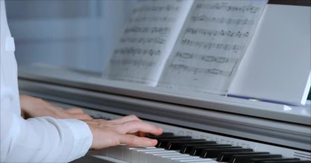 Frau oder Mädchen spielt ein Student oder professioneller Pianist klassische Musik auf einem schönen weißen Klavier, die Hände eines Pianisten in Nahaufnahme in Zeitlupe. Klaviertasten schließen sich in dunklen Farben. 4k — Stockvideo