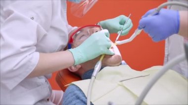 Diş Hekiminde Ağız Deliği 'nin Tıbbi Muayenesi ve Tedavisi Yapılmaktadır. Kadın Diş Hekimi Klinikte Erkek Hastayı Tedavi Ediyor. Kadın Profesyonel Doktor Stomatolojist İş Başında.