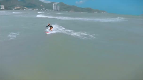 Légi kilátás felülről Atlétikai fiatal nők és férfiak szörföznek, lovagolni nagy hullámok fényes nappal, szörfös várja a hullám. — Stock videók