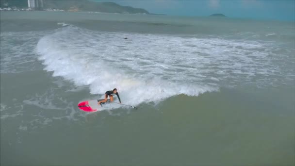 Légi kilátás felülről Atlétikai fiatal nők és férfiak szörföznek, lovagolni nagy hullámok fényes nappal, szörfös várja a hullám. — Stock videók