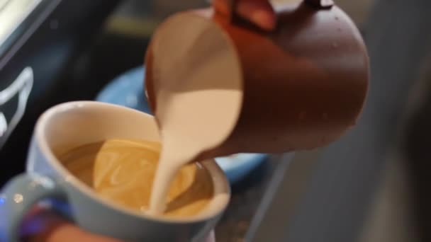 Professionele barista. Het maken van vers gemalen koffie, Barista het maken van Latte Art giet melk in een mok, terwijl het maken van een mooie tekening, waardoor de koffie nog meer wenselijk. — Stockvideo