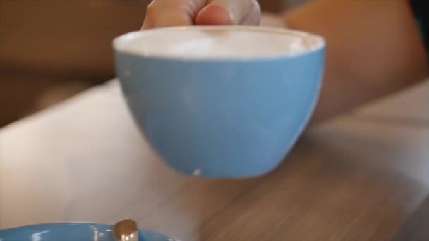 Close-up Portret Jonge mooie vrouw drinkt 's morgens koffie. jong meisje in mooie zonnige dag drankjes ochtend koffie in een cafe. — Stockvideo