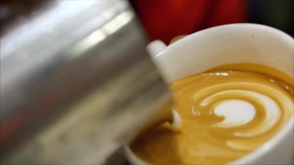 Professioneller Barista. Frisch gemahlener Kaffee, Barista macht Latte Art, die Milch in einen Becher gießt und dabei eine schöne Zeichnung macht, die den Kaffee noch begehrenswerter macht. — Stockvideo