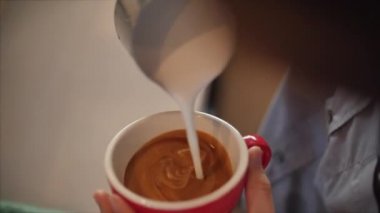 Profesyonel barista. Taze öğütülmüş kahve yapmak, Barista 'nın bir fincana süt dökerek güzel bir çizim yapması, kahveyi daha da cazip kılıyor..