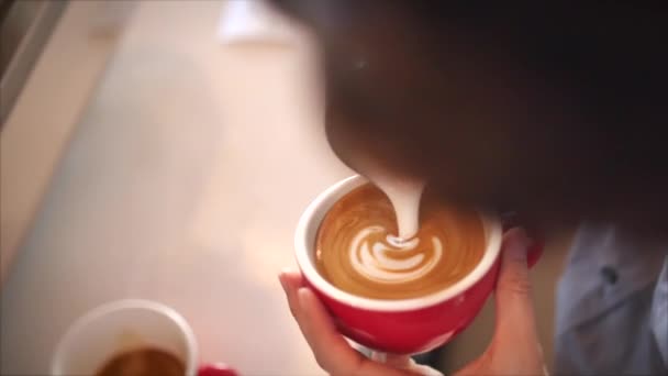 Barista zeichnet Latte Art auf Kaffee mit Sojamilch. Prozess der Herstellung von veganen laktosefreien Getränken im Coffeeshop. Professioneller Barista. — Stockvideo