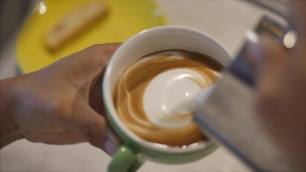 Barista zeichnet Latte Art auf Kaffee mit Sojamilch. Prozess der Herstellung von veganen laktosefreien Getränken im Coffeeshop. Professioneller Barista. — Stockvideo