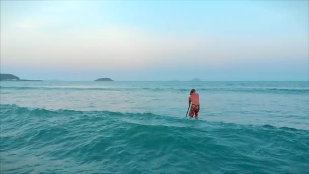 Surfare flyger på vågkrönet, en surfare kontrollerar åran, stående på en surfbräda. Surfare väntar på sin våg.. — Stockvideo