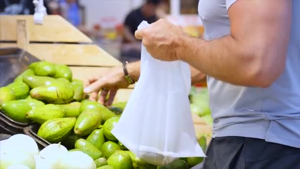 Sterke gezonde sportman koopt voedsel, Avocado 's in de supermarkt. — Stockvideo