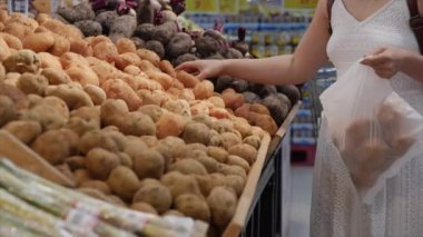 Kadın süpermarketten alışveriş yapıyor, marketten yemek, sağlıklı yiyecekler, domates, avokado, meyve, portakal ve süpermarket ürünleri seçiyor..