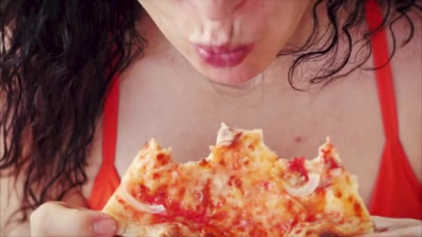Kırmızı elbiseli, genç, tatlı İtalyan görünümlü bir kadın restoranda İtalyan pizzası yiyip eğleniyor. Kadın yiyeceği, besin, kalori kavramı. — Stok video