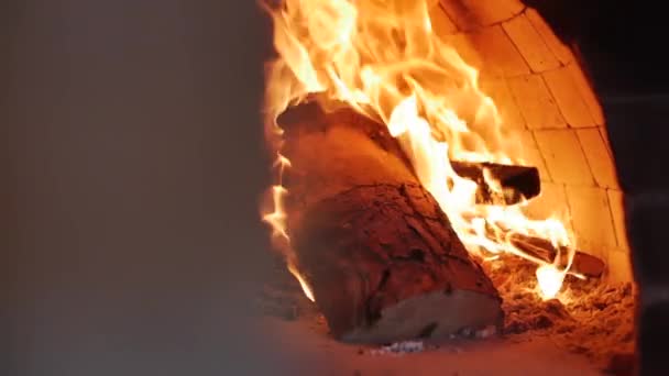 Movimiento en el control deslizante. El primer plano de la madera carbonizada se quema perfectamente en un horno de pizza. Coloque la pizza en un horno de pizza a leña usando corteza de pizza. Movimiento lento . — Vídeos de Stock