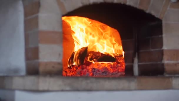 ピッツェリアの概念,火のオーブン,料理.ピザオーブンのようにスライダーでクローズアップムーブメントはちょうど良い新鮮なスロー薪を燃焼します。薪焼きのピザオーブンにピザを配置します。 — ストック動画