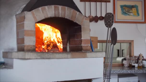Quadro como em um forno de pizza, lenha recém-assada está queimando. Coloque a pizza em um forno de pizza a lenha usando a casca da pizza . — Vídeo de Stock