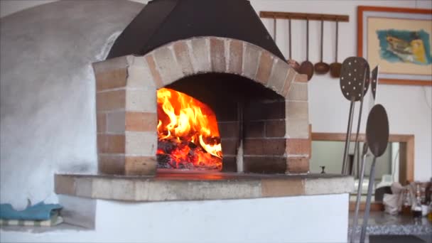 Mouvement lent de la caméra sur un cadre coulissant comme dans un four à pizza, le bois de chauffage fraîchement cuit brûle. Placez la pizza dans un four à pizza à bois à l'aide de la pelure de pizza .