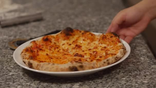 新鲜烤的意大利辣披萨，切成几块，配上美味的奶酪，放在外卖的披萨盒里。新烘焙的带有辣香肠披萨的木制披萨. — 图库视频影像
