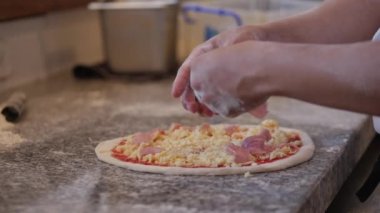 Gerçek pepperonili pizza, yemek pişirme metodu, İtalyan aşçı parmaklarıyla hamurdan gerçek İtalyan pizzası yapıyor, pizzaya füme sosis serpiştiriyor..