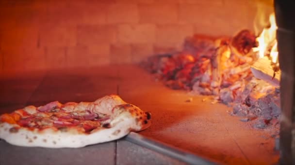 Pizzeria Master Haciendo una pizza italiana de verdad, comprueba la preparación de la pizza sacándola del horno de pizza usando la corteza de la pizza . — Vídeos de Stock