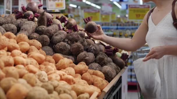 Mujer está haciendo compras en el supermercado, la elección de productos en el supermercado para cocinar, alimentos saludables, tomates, aguacates, frutas, naranjas en el mercado, supermercado . — Vídeo de stock