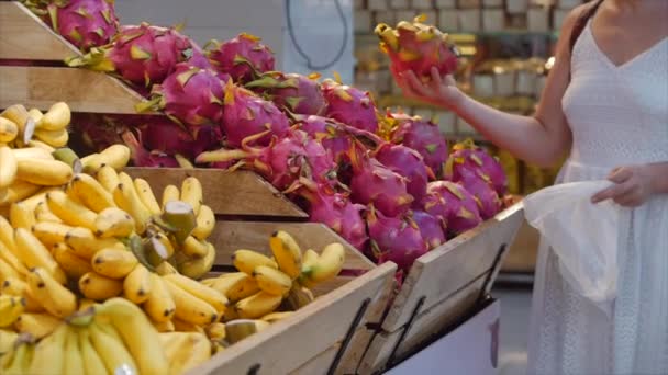 Söt ung kvinna gör inköp i snabbköpet, välja produkter i snabbköpet för matlagning, hälsosam mat, drake frukt, mango, på marknaden, snabbköp. — Stockvideo