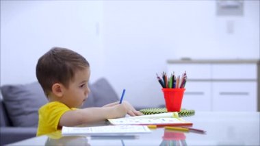 Mutlu aile annesi, dadı evde masa oyunu oynayan sevimli çocuğu öğreniyor, anne bebeğe kalemlerle resim çizmeyi öğrenmesinde yardımcı oluyor, yaratıcı sürecin tadını çıkarıyor..