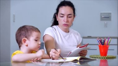Mutlu aile annesi, dadı evde masa oyunu oynayan sevimli çocuğu öğreniyor, anne bebeğe kalemlerle resim çizmeyi öğrenmesinde yardımcı oluyor, yaratıcı sürecin tadını çıkarıyor..