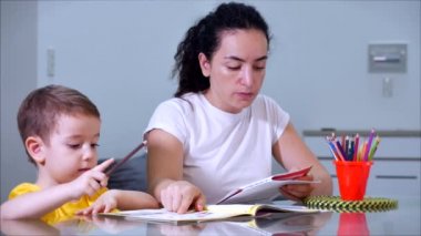 Mutlu aile annesi, dadı evde masa oyunu oynayan sevimli çocuğu öğreniyor, anne bebeğe kalemlerle resim çizmeyi öğrenmesinde yardımcı oluyor, yaratıcı sürecin tadını çıkarıyor..