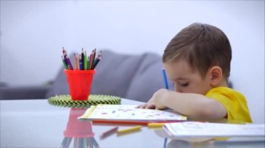 Mutlu aile annesi, dadı evde masa oyunu oynayan sevimli çocuğu öğreniyor, anne bebeğe kalemlerle resim çizmeyi öğrenmesinde yardımcı oluyor, yaratıcı sürecin tadını çıkarıyor..