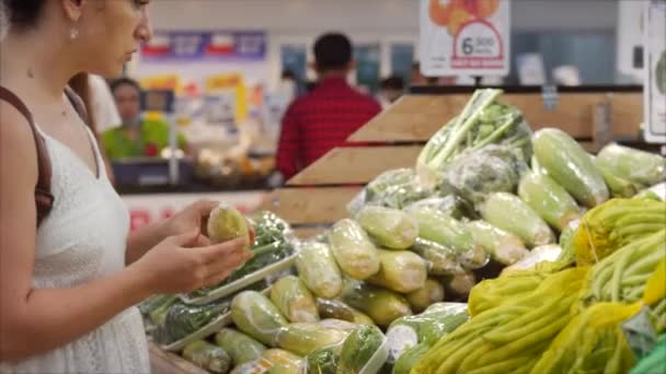 Junge Frau kauft im Supermarkt ein, gesunde Lebensmittel, Mais auf dem Markt, Supermarkt. Die Wahl der Lebensmittel im Supermarkt zum Kochen. Konzept des Warenkaufs. — Stockvideo