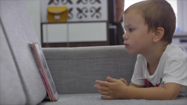 Anak kecil memegang pad komputer berselancar internet bermain game di rumah. Konsep kecanduan teknologi anak-anak — Stok Video