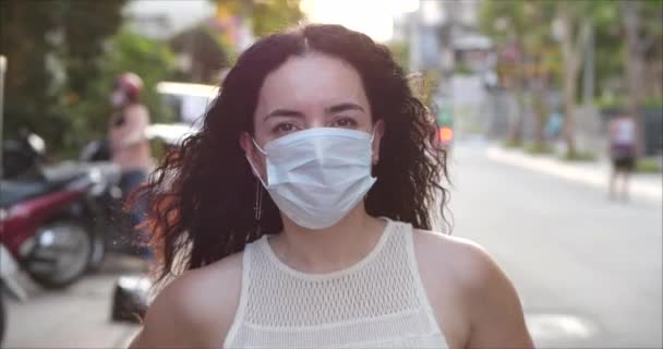 Ritratto di una giovane donna mascherata da un'epidemia di coronavirus che indossa una maschera protettiva chiedere in strada. Concetto di salute e sicurezza Vita, Covid-19, protezione dai virus, pandemia a parole. Coronavirus N1H1 — Video Stock