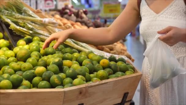 Flicka gör inköp i en stormarknad, hälsosam mat, kalk på marknaden, snabbköp. Begreppet att köpa produkter. Välja mat i snabbköpet för matlagning. — Stockvideo