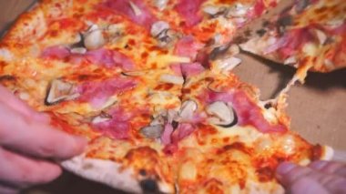 Yetişkinler ve çocuklar aile bireylerinin elleri açık bir kutudan sıcak İtalyan pizzasından dilimler kaldırır. Yiyecek atıştırma konsepti, Corontina 'da yemek servisi, birlikte yemek yemek yemek.