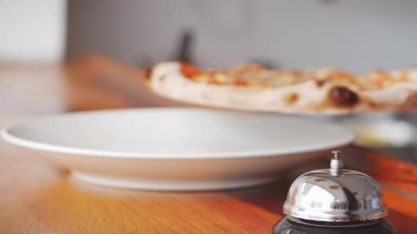 Italiaanse chef-kok bereidt echte Italiaanse pizza, zet de afgewerkte pizza op het bord en drukt op het signaal. Pizza is klaar. U kunt een bestelling ophalen voor een aangename eetlust. Echte peperoni pizza, geweldig.. — Stockvideo