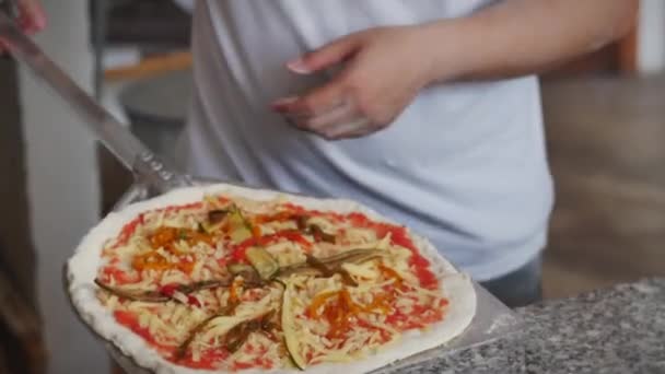 Pizza în cuptor. Un foc arde în cuptor. Pune pizza în cuptor, începe să gătească, o pune în cuptorul de pizza cu ajutorul cojii de pizza . — Videoclip de stoc