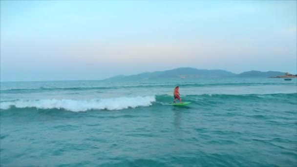 Surfer vliegt op de kam van een golf, een surfer bestuurt de roeispaan, staande op een surfplank. Surfer wacht op zijn golf.. — Stockvideo