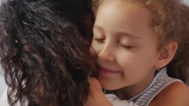 Mutlu aile kavramı. Sevimli, sevecen bir kız evlat edinilmiş, küçük bir kız çocuğu. Anne, anne, baba, kapalı gözlü, sevimli kız, anneye sarılmış, tatlı bir anın tadını çıkarıyor.