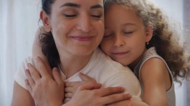 Mutlu aile kavramı. Sevimli, sevecen bir kız evlat edinilmiş, küçük bir kız çocuğu. Anne, anne, baba, kapalı gözlü, sevimli kız, anneye sarılmış, tatlı bir anın tadını çıkarıyor.