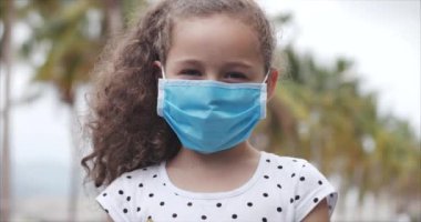 Covid-N1H1 salgınından kalma koruyucu maskelerle sokakta duran sevimli küçük kız. Yaşam Sağlığı ve Güvenliği kavramı, Covid-19, Virüs Koruması, Sözde bir Salgın. Coronavirus N1H1.