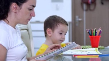 Mutlu anne, evde masa başı oyunları oynayan şirin çocuğu öğreniyor. Anne, bebeğe kalemlerle resim çizmeyi öğrenmesinde yardımcı oluyor. Yaratıcı sürecin tadını çıkarıyor. Covid-19, virüs koruması, kelimenin tam anlamıyla salgın.