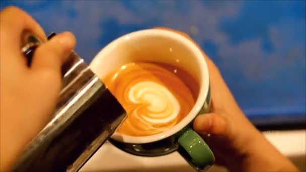 Fazendo café moído na hora, Barista fazendo Latte Art derramando leite em uma caneca enquanto faz um belo desenho, o que torna o café ainda mais desejável. Barista profissional . — Vídeo de Stock